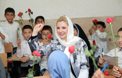نیوشا ضیغمی با گل‌های کودکان کار به مدارس رفت / گزارش تصویری